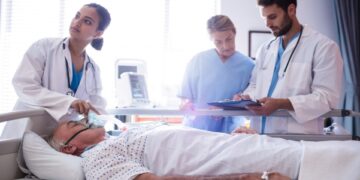 Female doctor putting oxygen mask on patient face in the hospital