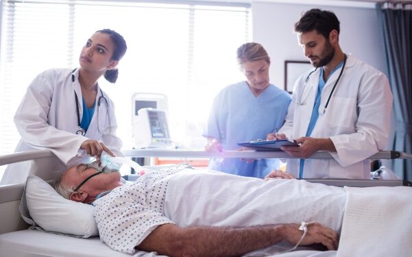 Female doctor putting oxygen mask on patient face in the hospital